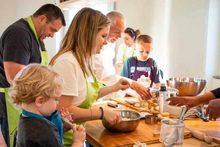 Family learns to cook handmade pasta during a Cooking workshop of Rome for kids