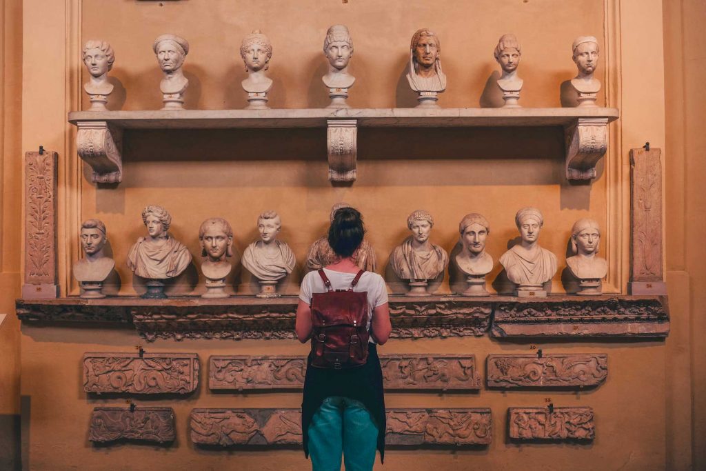 Girl in front of Roman statues at Vatican Museums during a tour with Rome for kids